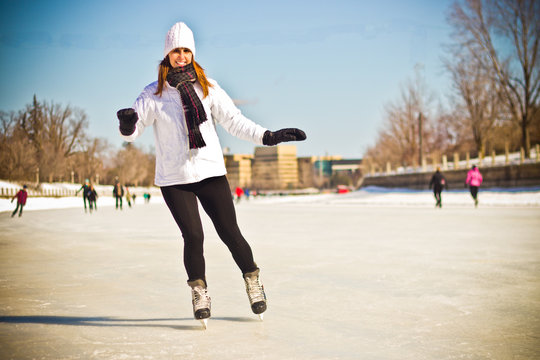 Attractive young woman ice skating during winter - retro filter