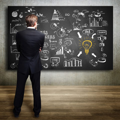 Geschäftsmann vor umfangreichem Business-Plan