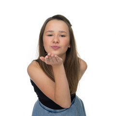 Fototapeta premium Playful young girl blowing a romantic kiss