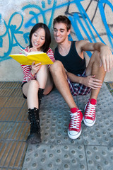 Young multi-ethnic couple reading a book.
