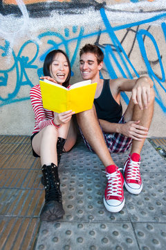 Young multi-ethnic couple reading a book.