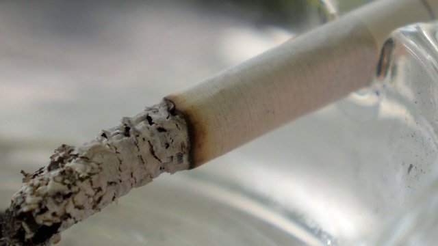 Closeup of Smoldering Cigarette on Ashtray. Speed up.