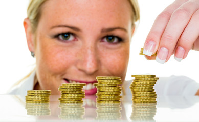 Frau mit Münzstapel beim Geld sparen
