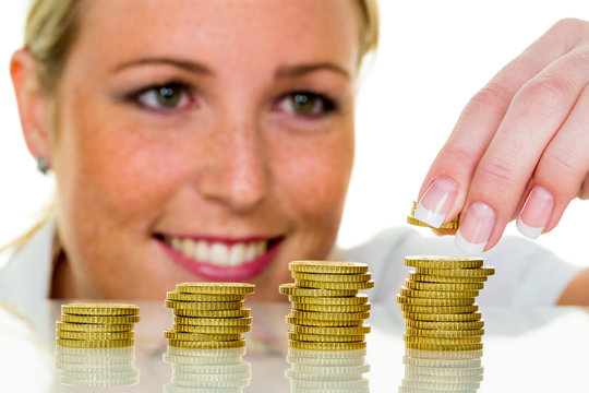 Frau mit Münzstapel beim Geld sparen