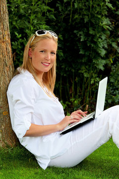 Frau mit Laptop Computer im Garten