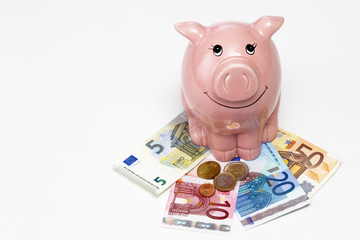 Rosa Sparschwein mit Geld auf weißem Hintergrund