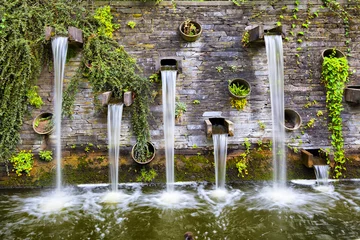 Fotobehang Rotswand met kleine watervallen in park Planten un Blomen © bbsferrari