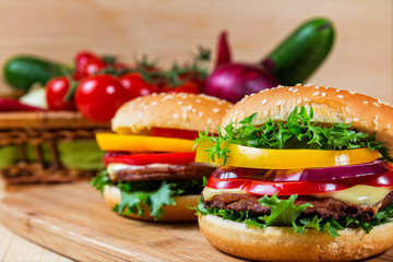 homemade hamburger with fresh vegetables on cutting board