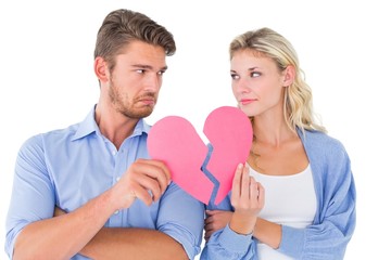 Couple holding two halves of broken heart