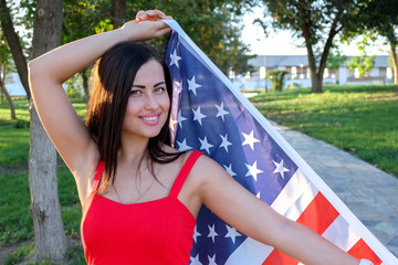 Happy young woman holding american flag