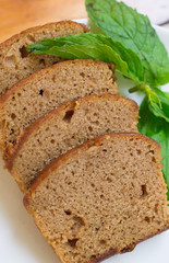 Slices of banana cake on white plate with leaves of mint