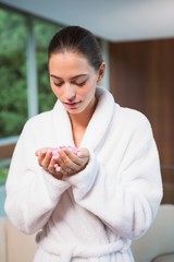 Woman in bathrobe holding flowers in spa