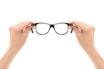 Male hands holding a pair of glasses