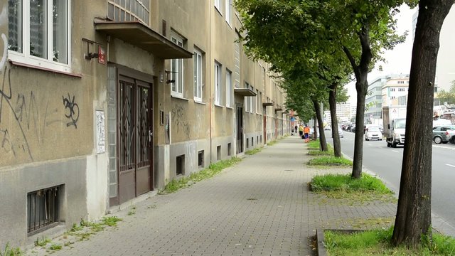 urban street with road - buildings (flats) - passing cars