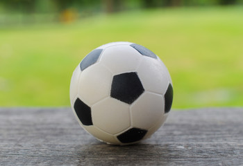 soccer football on plank with green background