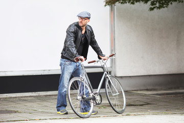 Fototapeta na wymiar Mann mit Fahrrad vor Schaufenster