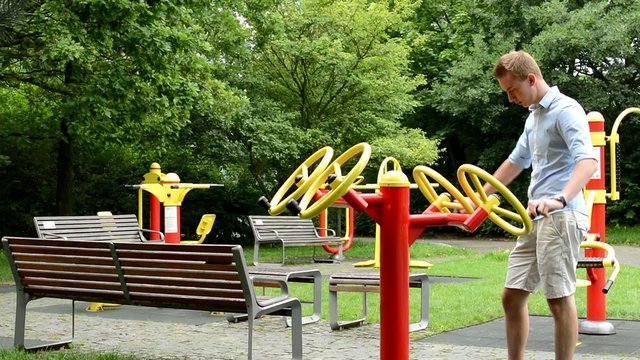 senior park (exercise machines) with benches- man strengthens