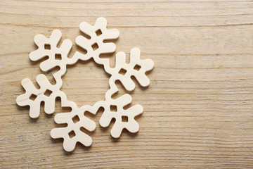 Fototapeta na wymiar Snowflake made of wood on wooden background
