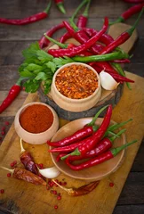 Fotobehang Red chilli peppers and spices on the table © pilipphoto