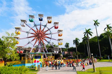 Fotobehang Amusementspark kleurrijk reuzenrad in de speeltuin tegen de blauwe lucht