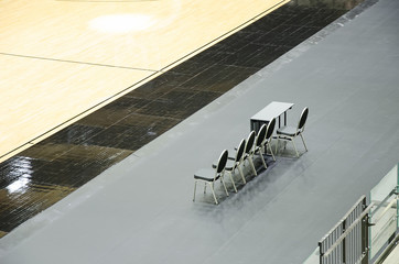 Empty chairs for coaches on the basketball arena.