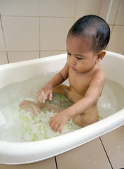 Cute Asian baby boy playing in bathroom