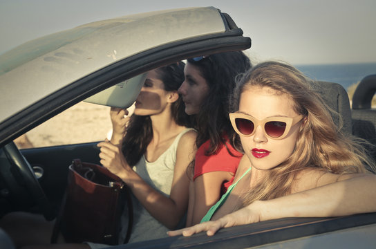 three young women on a car