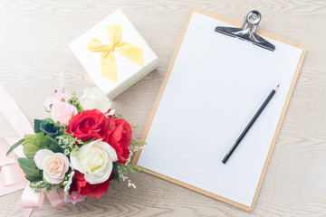 Wooden Clipboard attach planning paper with pencil beside rose b