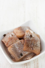 herring in white dish on white background