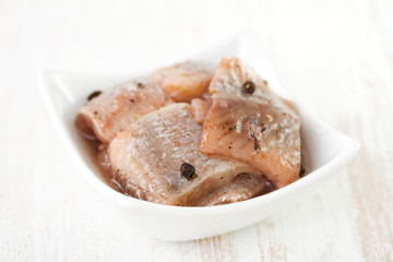 herring in dish on white background