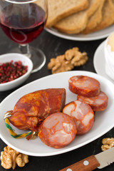 chorizo on plate with glass of wine