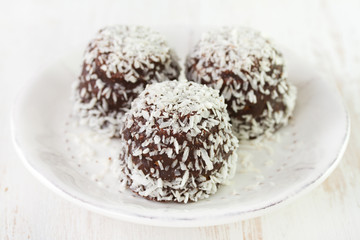 chocolate coconut sweets on plate on white background