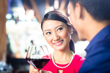 Asian couple with wine in Restaurant