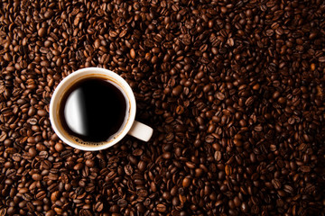 cup of black coffee with roasted coffe beans
