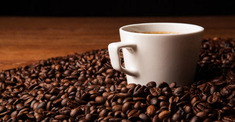 cup of black coffee with roasted coffe beans