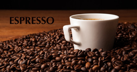 cup of black coffee with roasted coffe beans