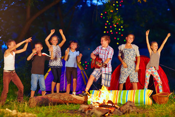 happy kids dancing around campfire © Olesia Bilkei