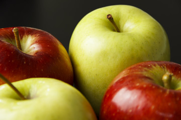 Four apples on black background.