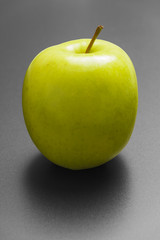 Green fresh apple on silver background