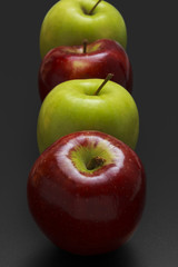 Four apples on black background.