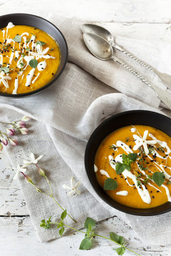 cream of pumpkin and carrot soup on bowls with sour cream