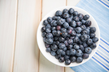 fresh blueberries ion white plate on kitchen table