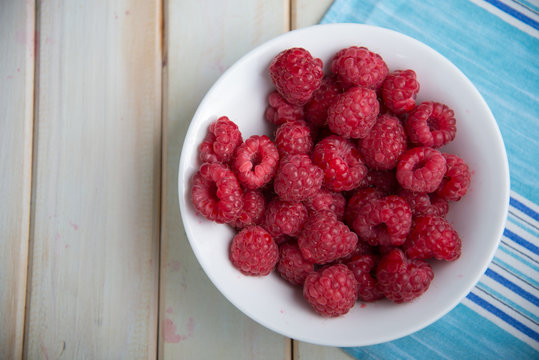 fresh raspberries on plate on kitchen table
