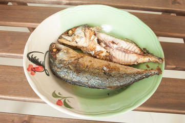Fried Mackerel in dish on wooden table.