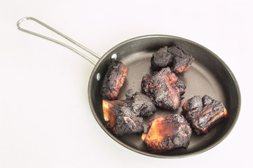 Burns pork ribs in pan.