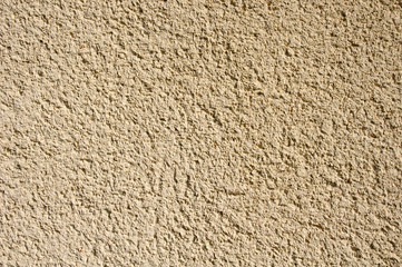 Light yellow rough plaster on wall closeup