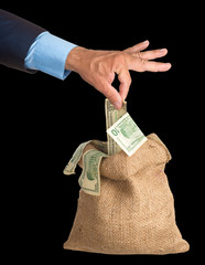 Hand pulls money out of the bag. isolated.