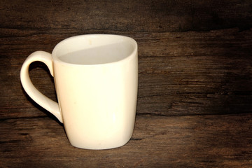 White coffee cup on wooden background.