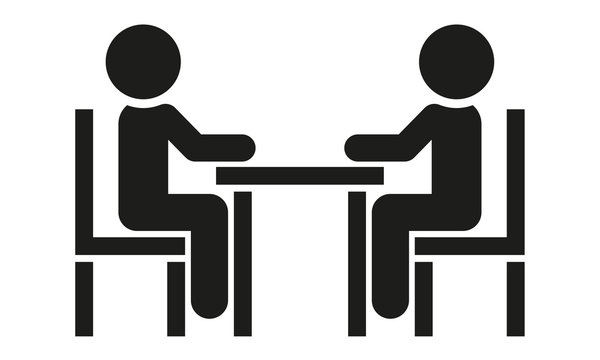 Zwei Menschen sitzen am Tisch