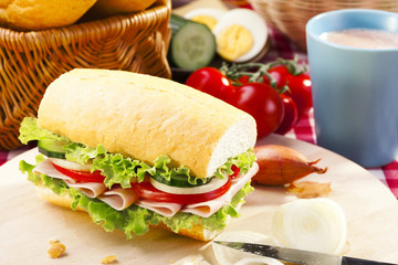 Breakfast sandwich with vegetables and a cup of hot cocoa.
